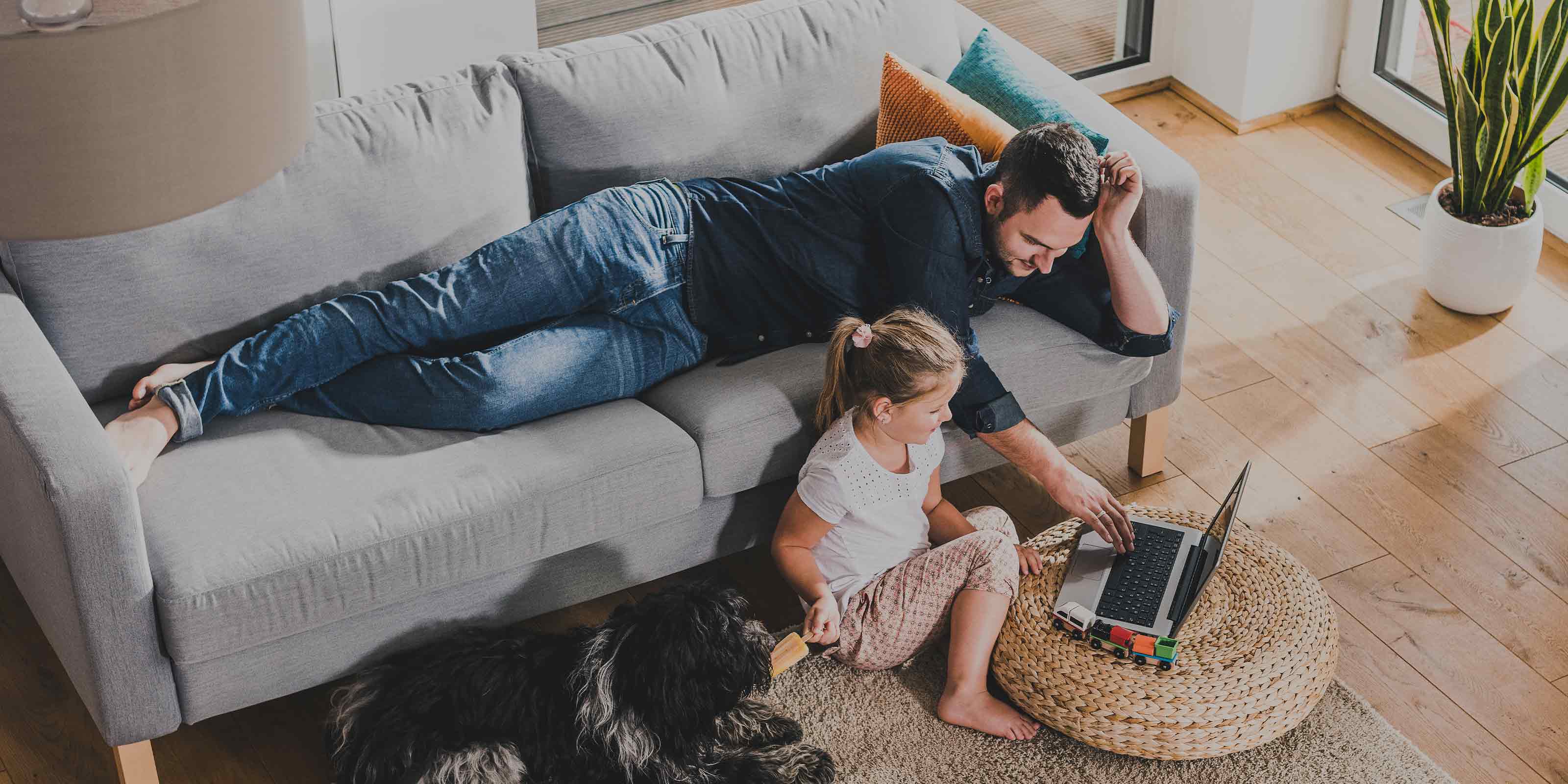 Père et sa fille utilisant un ordinateur portable dans le salon. 