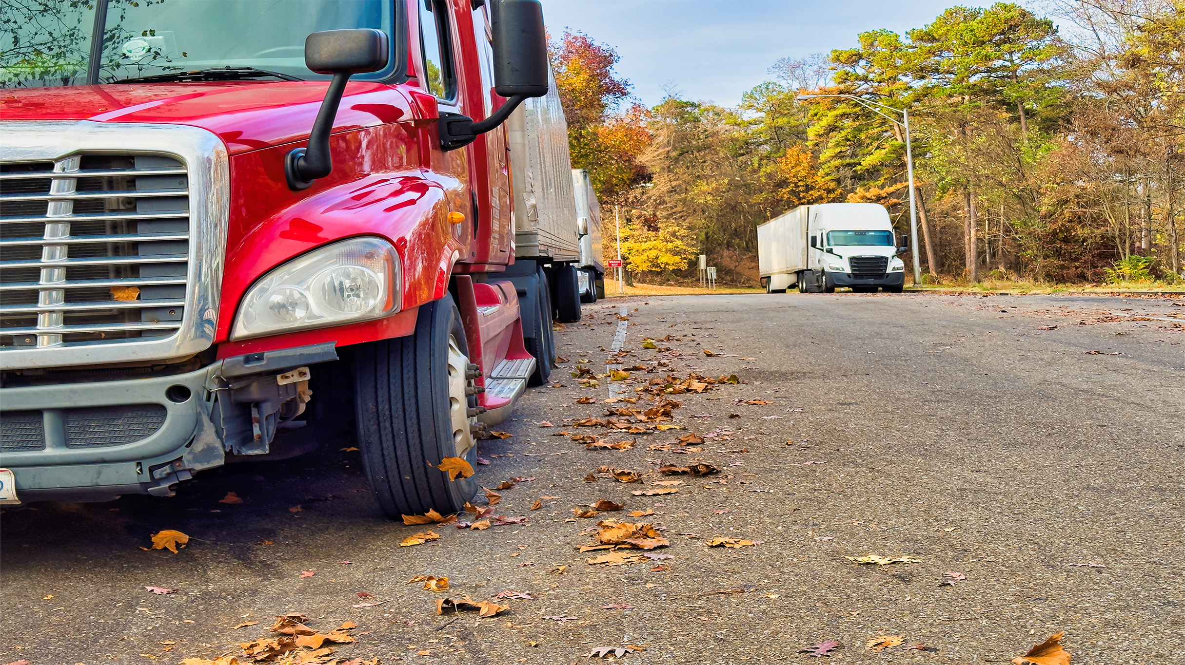 Transport trucks parked at a vehicle inspection station parking lot.