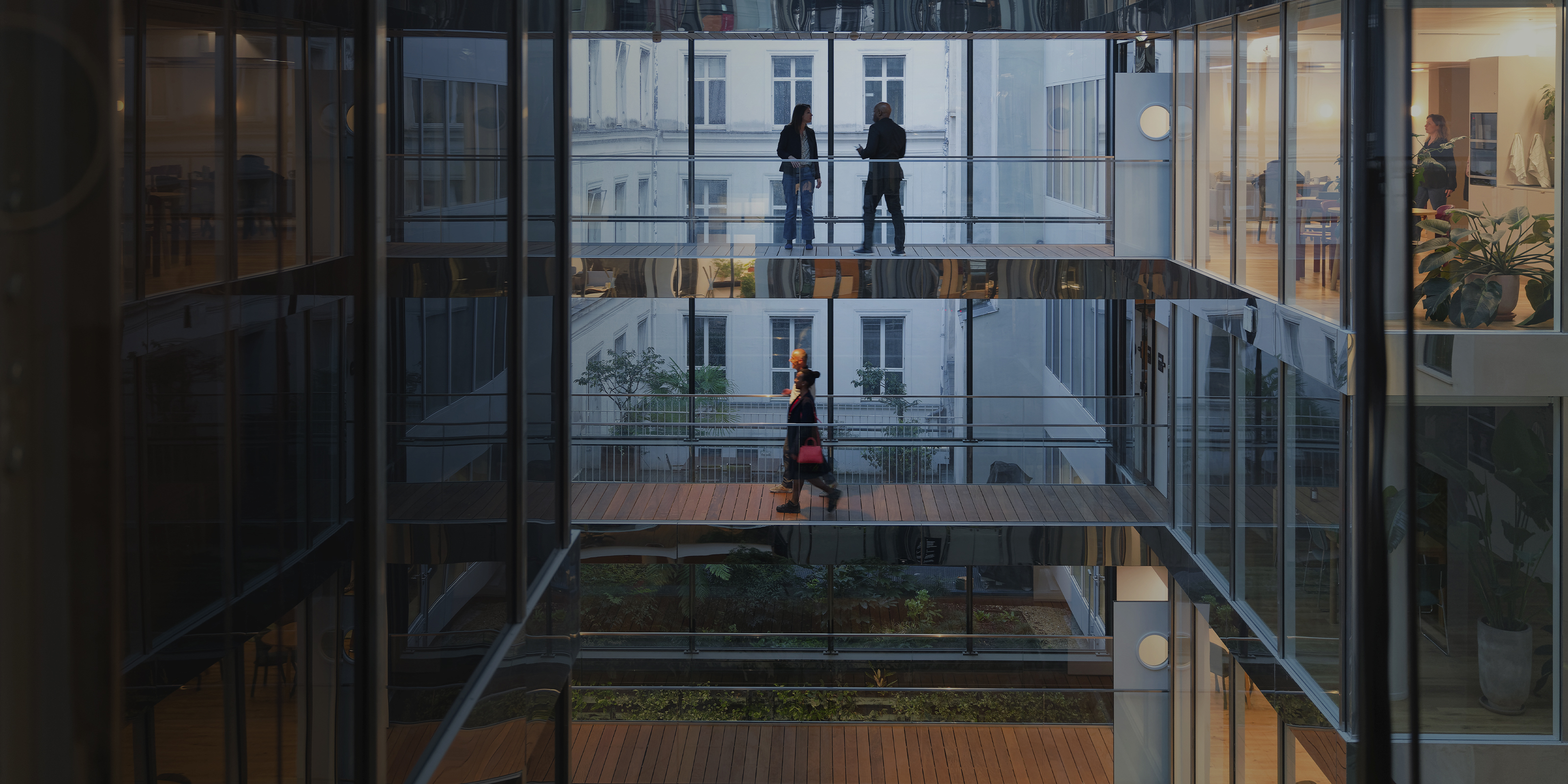 Modern office building with colleagues crossing a raised bridge