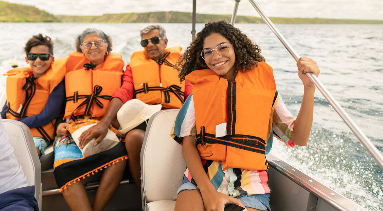 Father and daughter sitting on front of speed boat while mother watches